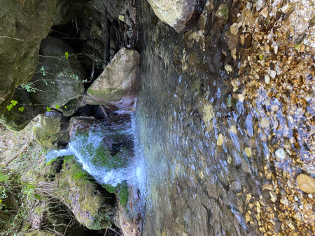 Crystal clear water cascading among rocks and lush moss creates a serene waterfall in the picturesque landscape of Abruzzo, Italyの写真素材