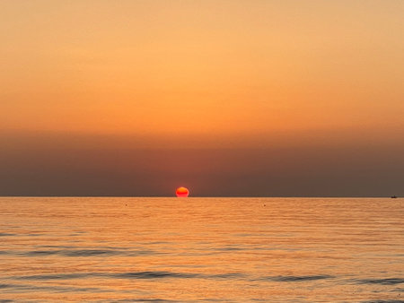 Beautiful sunset over the calm sea, creating a peaceful and romantic atmosphereの写真素材