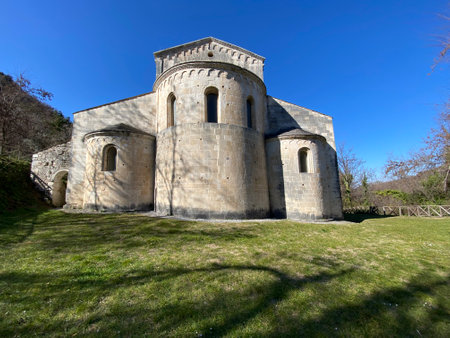 Historic medieval San Liberatore Abbey nestled on verdant landscape, sunlit mountain backdrop near Serramonacesca, Abruzzo, Italyの写真素材