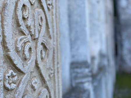 Weathered stone pillar featuring intricate medieval carvings representing architectural heritage of Serramonacesca, Abruzzo regionの写真素材