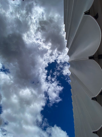 White facade of a modern building rising against a cloudy sky in Pescara, Abruzzo, Italy, showcasing contemporary architectural designの写真素材