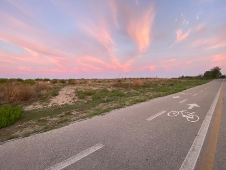 Winding coastal bike path near Abruzzo, Italy, revealing golden sunset hues against Adriatic seascape, highlighting eco-friendly transportation and scenic landscapesの写真素材
