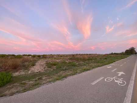 Breathtaking sunset illuminating a bike path in Abruzzo, Italy, with vibrant pink clouds adorning the evening sky, creating a serene atmosphereの写真素材