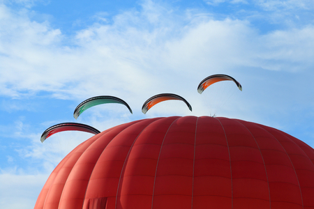Paragliders make the spectacular perform between hot air balloonsの写真素材
