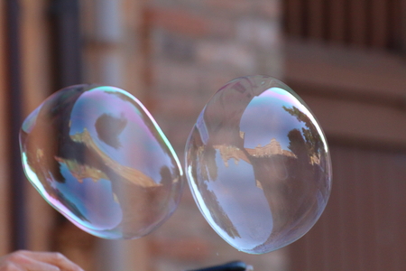 Giant soap bubbles created with ropes and sticks in the cityの写真素材