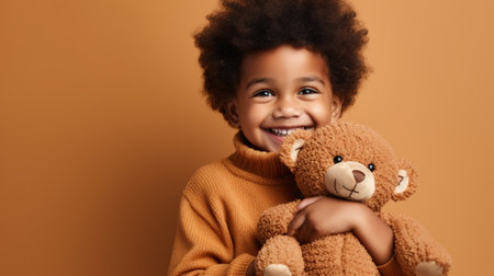 Cheerful african american little boy with teddy bear on brown backgroundの素材