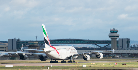 GATWICK AIRPORT, ENGLAND, UK â DECEMBER 09 2018: An Emirates Airline A380 Airbus taxis after landing at London Gatwick Airport, with the air traffic control tower in the background. Copy space.のeditorial素材