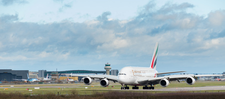 GATWICK AIRPORT, ENGLAND, UK â DECEMBER 09 2018: An Emirates Airline A380 Airbus taxis after landing at London Gatwick Airport, with the air traffic control tower in the background. Copy space.のeditorial素材