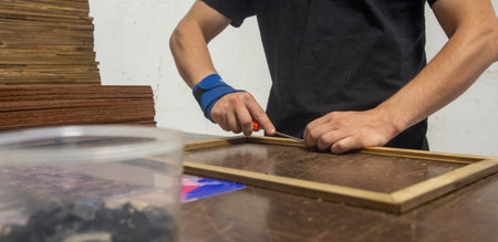 framemaker using his hands to finish his jobの写真素材