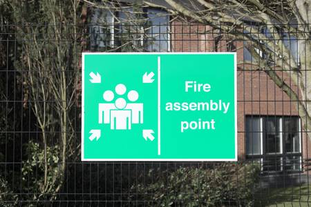 Fire assembly point sign at office factory workplace for security safety of workers people employeesの写真素材