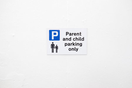 Parent and child parking only sign in car park on blank white wall