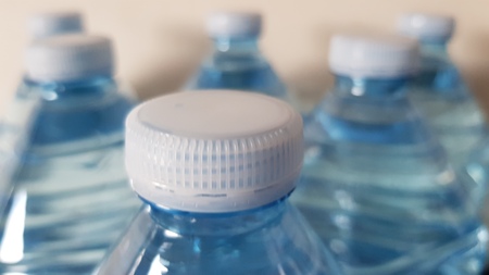 plastic bottles focused on the first row of caps.の写真素材
