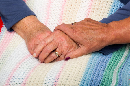 Holding a Senior Citizens Hand. Female hand holding the hands of a senior citizen in a wheelchair.