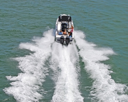 Motorboat with four people aboard speeding across biscayne bay on a saturday afternoonの写真素材