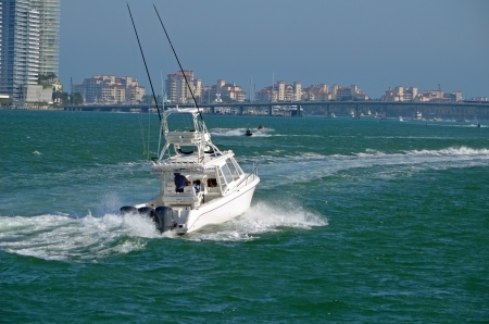 Sports fishing boat cruising on the florida intra-coastal waterway with Miami Beach and Fisher Island condo buildings in the background.の写真素材