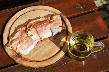 Bread with bacon on a wooden plate and a glass of apple juiceの写真素材