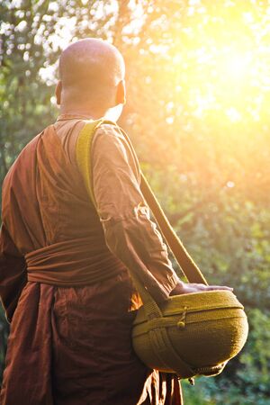 A monk goes for alms in early morning.の写真素材