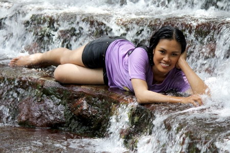 Sexy Filipina lying in a natural fresh water spring with flowing water around herの写真素材