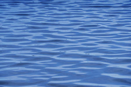 Gentle soft waves reflecting the blue skyの写真素材