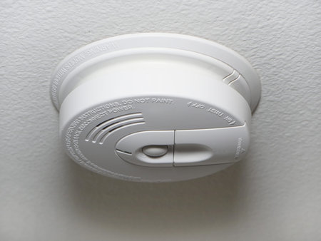 Close up of a ceiling mount white smoke detector used in homes.