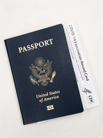 Costa Mesa, CA - March 16, 2021: Passport and Official Covid-19 Vaccination Record Card on deskのeditorial素材