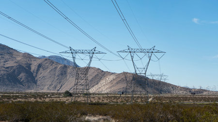 High tension power towers and lines stretching across desert.の写真素材