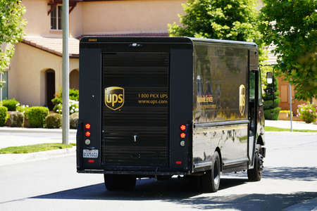 Lake Elsinore, California USA - May 15, 2022 UPS mail truck on city street, neighborhood residential district.のeditorial素材