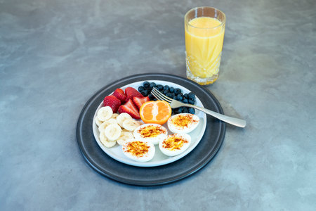Close up of fresh and healthy breakfast: Hard boiled eggs with fruit and orange juiceの写真素材