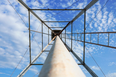 Looking up at an old style windmill tower on a sunny day