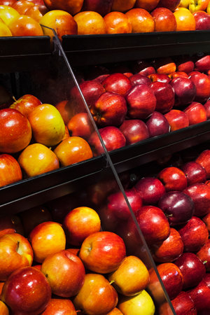 A variety of fresh apples on display at a supermarketの写真素材