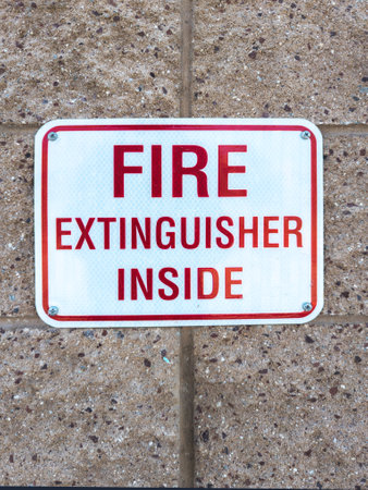 Red and white fire extinguisher inside signの写真素材