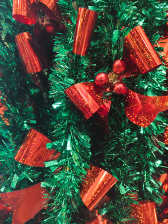 Close-up red bow on green foil garlandの写真素材