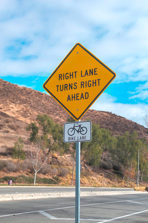 Road sign warning that right lane turns right aheadの写真素材