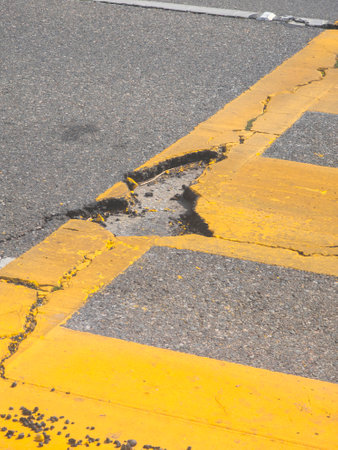 Pothole on the pedestrian crossing on the roadの写真素材