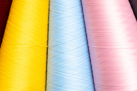Colorful threads for sewing on a wooden background close-up.