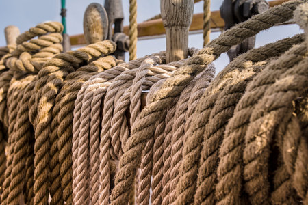 Ropes and wooden pulley in an old yacht, sunsetの写真素材