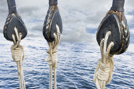 Wooden pulley on old yacht. Sea and low clouds. Replica of old vessel.の写真素材