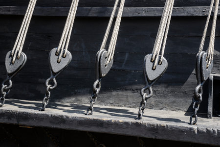 Wooden pulley on old yacht. Sea and low clouds. Replica of old vessel.の写真素材