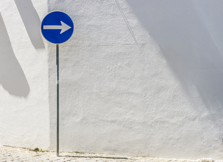 Road-sign on the white wall background.の写真素材