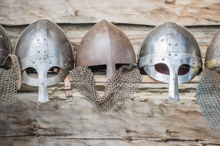 Replica of a medieval warrior Viking helmets on wooden background.の写真素材