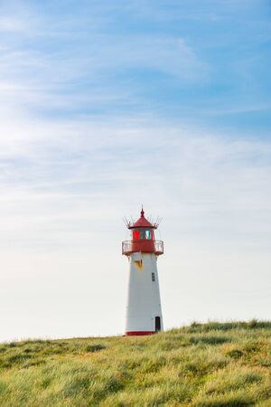 Lighthouse red white on dune vertical. Focus on background with lighthouse.の写真素材