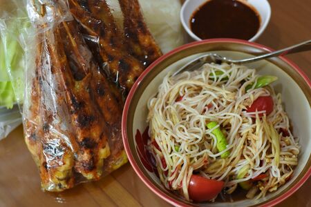 spicy papaya salad with grilled chicken wingの写真素材