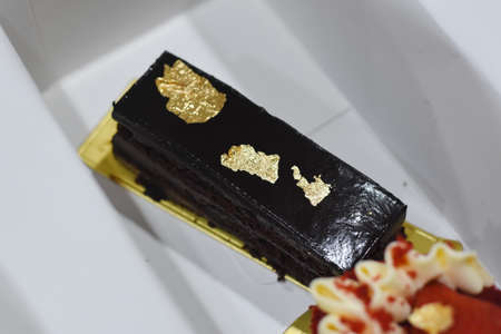 Black and gold chocolate cake on a white background. Luxury dessert.の写真素材