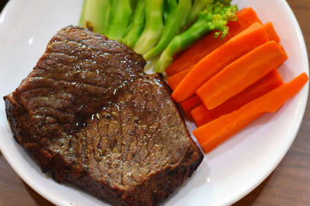 Beef steak with carrot and vegetable on white plate. Top view.の写真素材