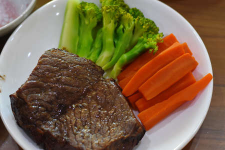 Beef steak with carrot and broccoli on white plate. Healthy food.の写真素材