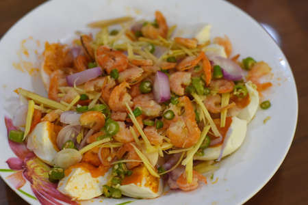 Shrimp salad with egg and red onion on white plate, Thai foodの写真素材
