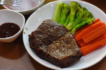 Beef steak with vegetables on wooden table. Selective focus.の写真素材