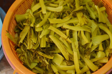 Close up of pickled celery in orange plastic basket for saleの写真素材