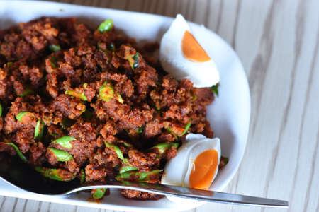 Spicy minced pork salad with egg on wood background. Thai foodの写真素材