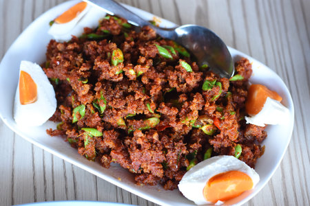 Spicy minced pork salad with egg on wooden background.の写真素材